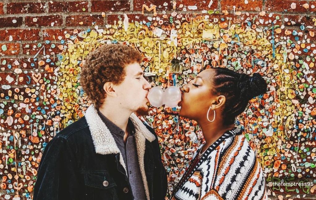 Couple kissing in front of the Gum Wall in Pike Place Market